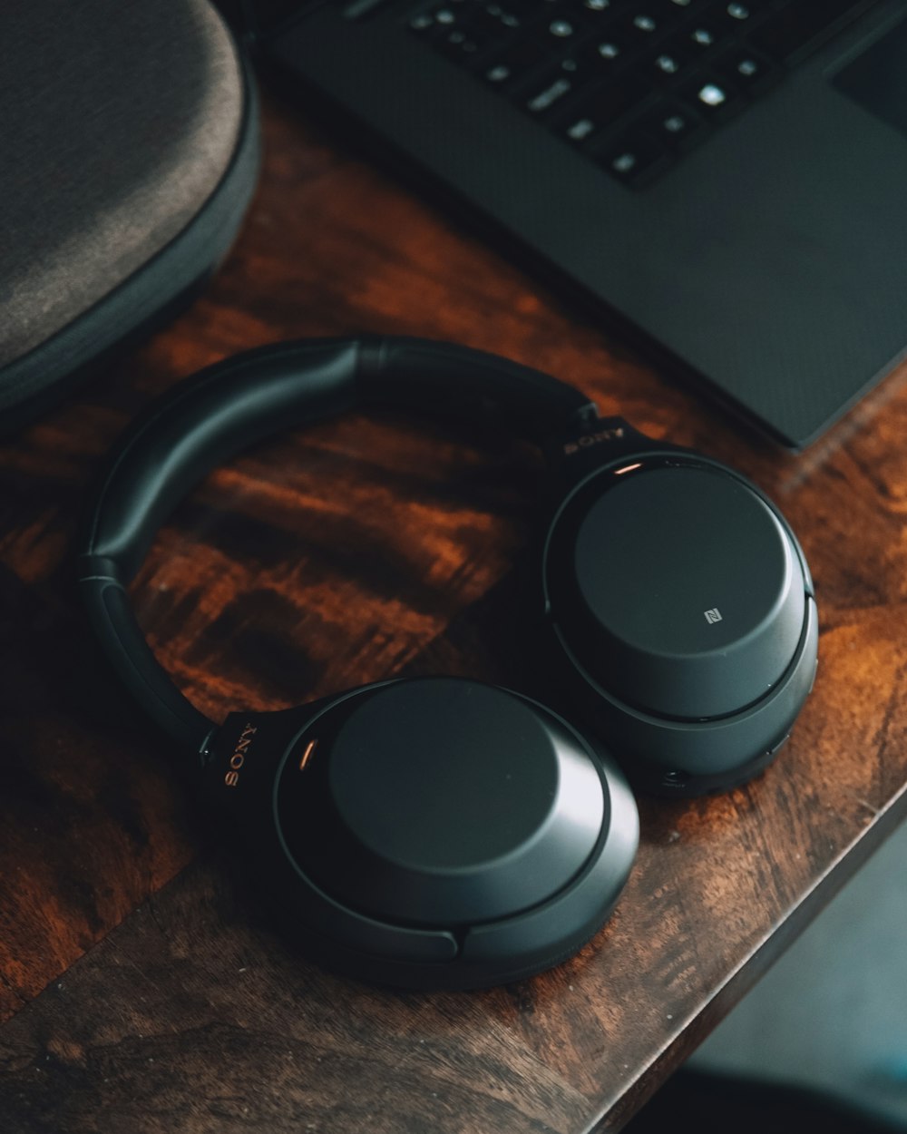 black sony headphones on brown wooden table