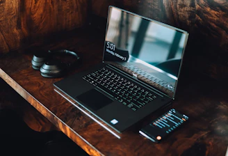 black asus laptop computer on brown wooden table