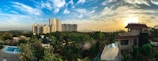 Panoramic render of the urbanization showing eco-friendly homes and green spaces at sunrise.