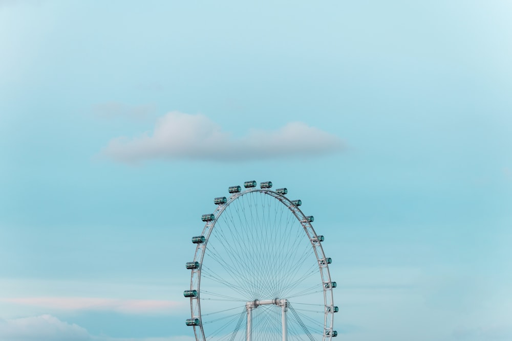 roda gigante sob nuvens brancas durante o dia