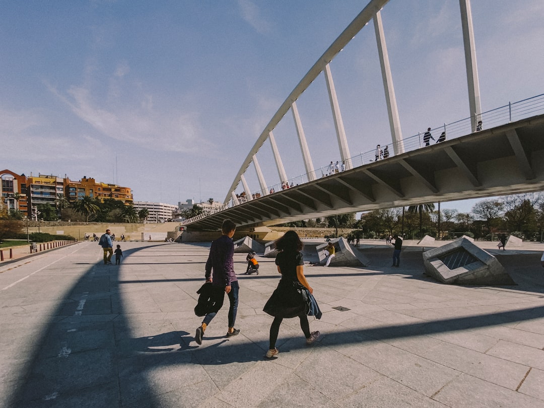 people walking on gray concrete pavement under gray sky during daytime