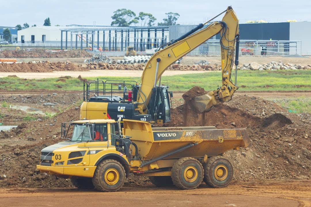 yellow and black UNK loader, Heavy vehicles at work at roads construction site.