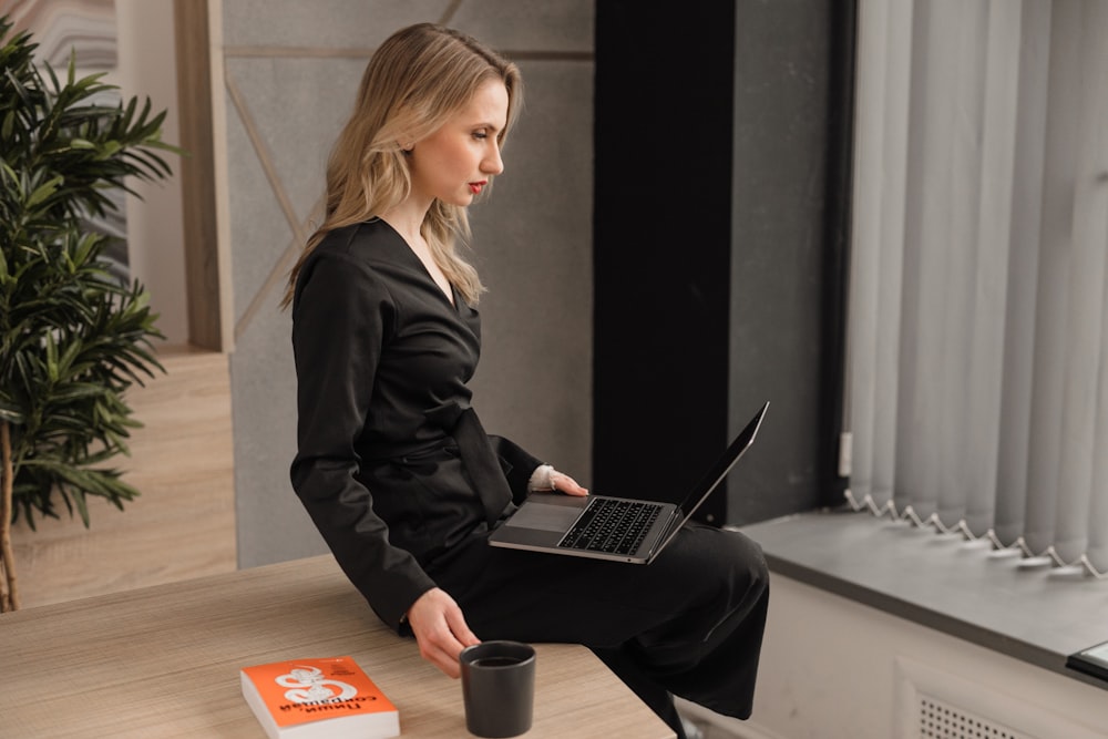 woman in black blazer using macbook pro