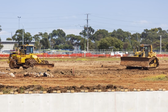 yellow and black heavy equipment on brown field during daytime