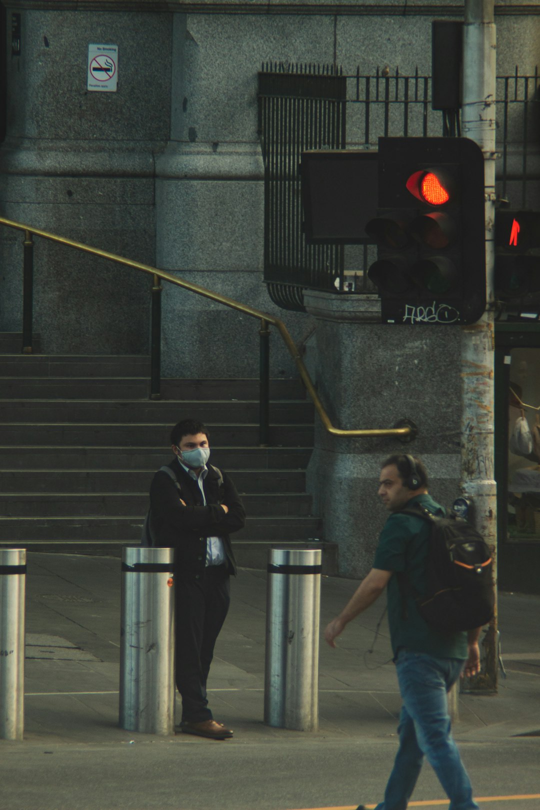 man in black jacket and black pants standing on stairs