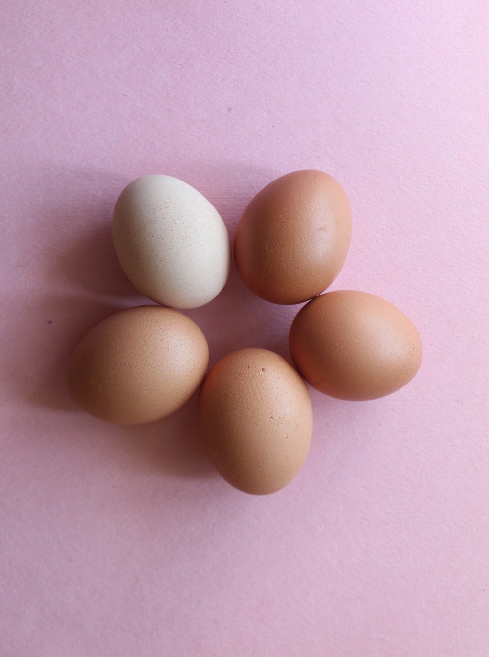 2 huevos marrones sobre tela rosa
