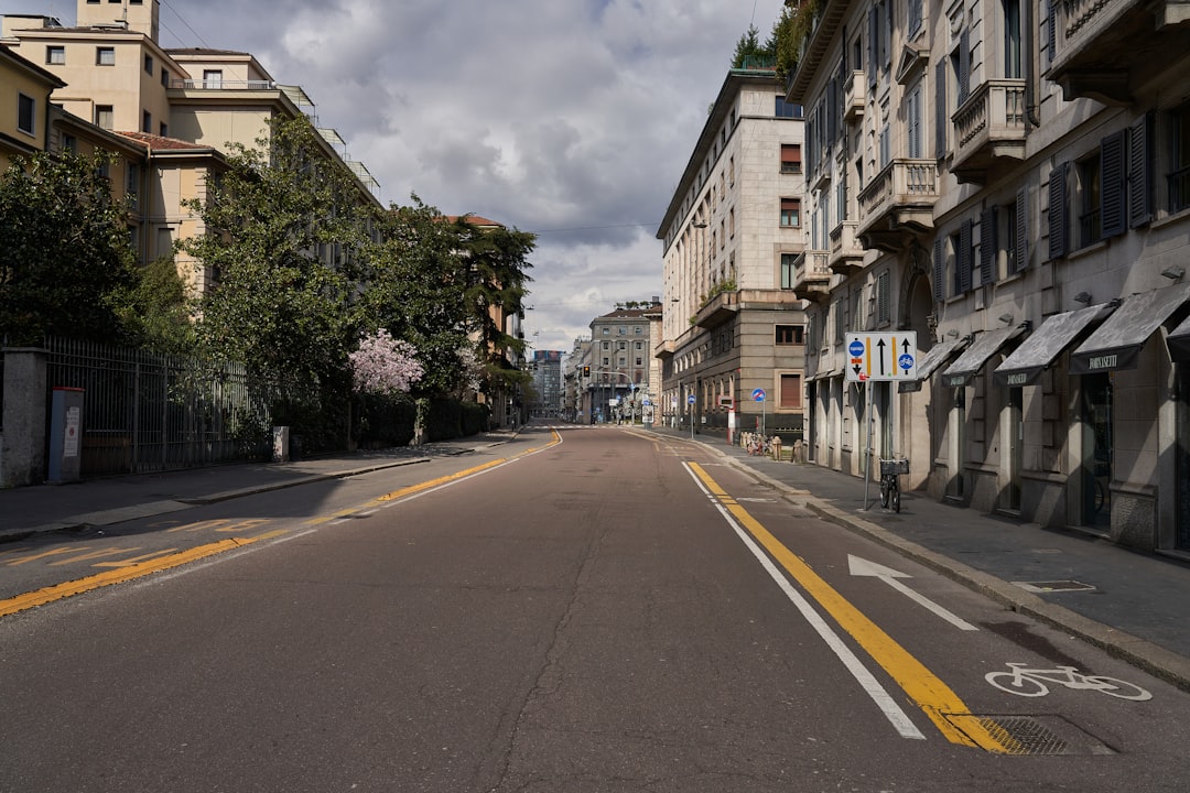 gray concrete road between buildings under gray sky during daytime