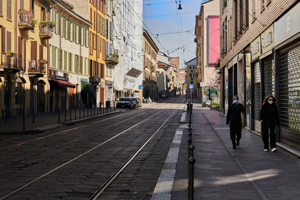 people walking on sidewalk near buildings during daytime