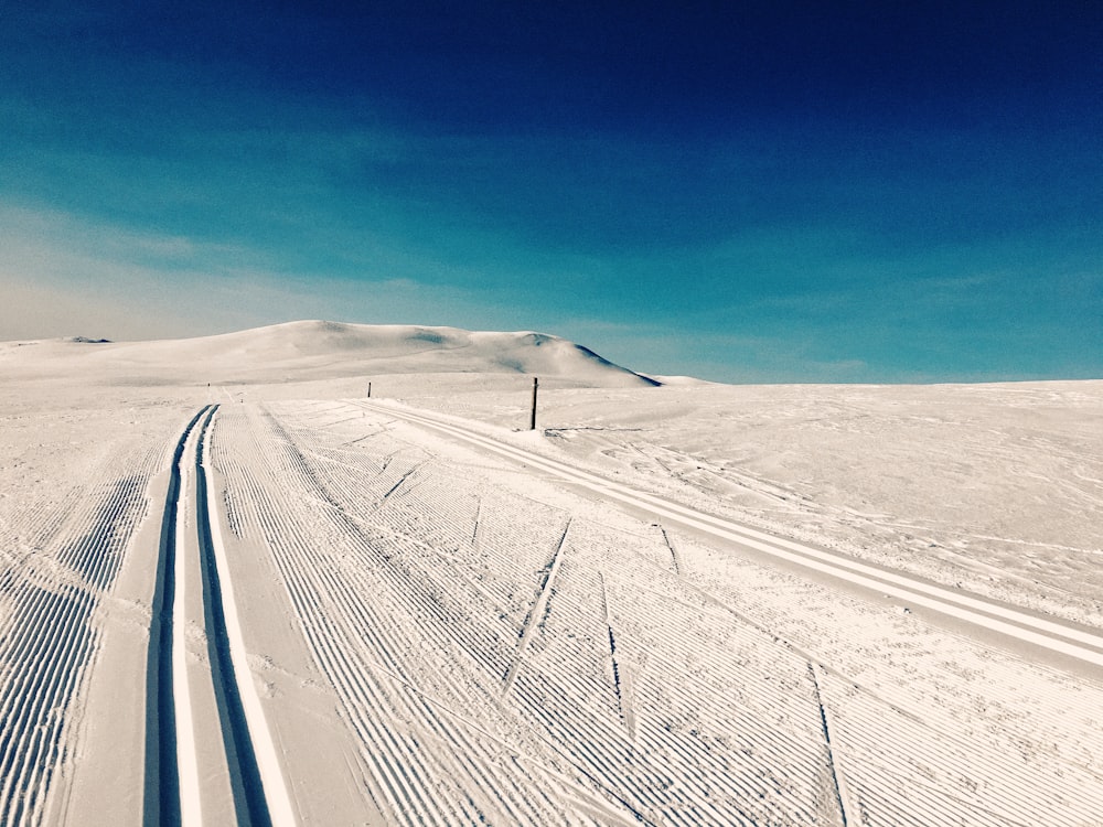 snow covered road under blue sky during daytime