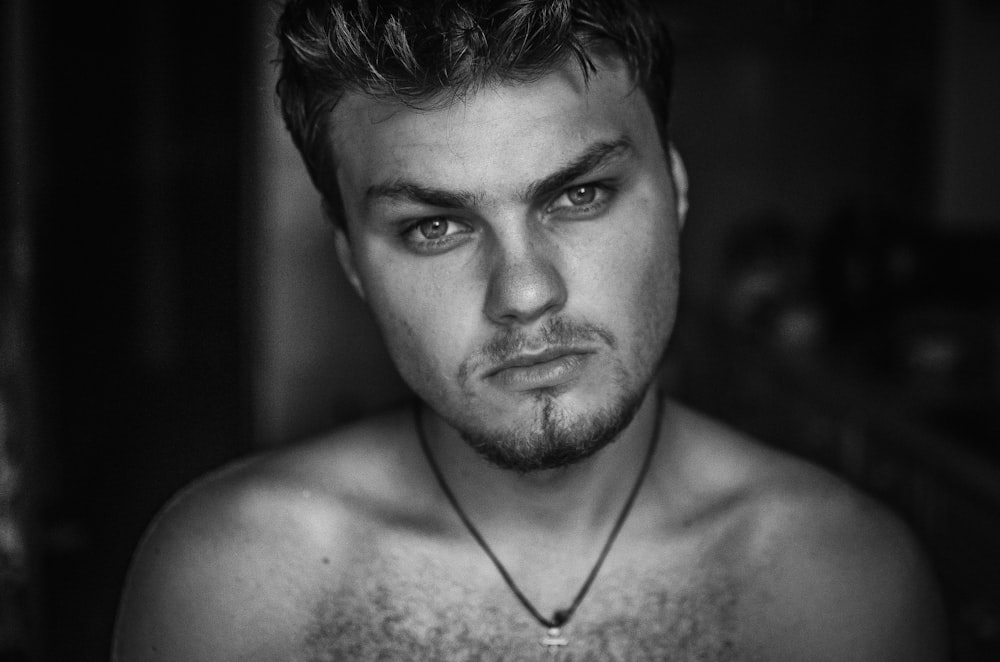 grayscale photo of topless man wearing silver necklace