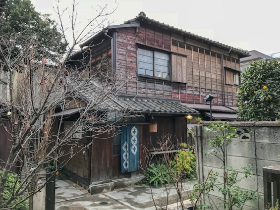 Traditional Japanese house with wooden facade and garden in a peaceful neighborhood.