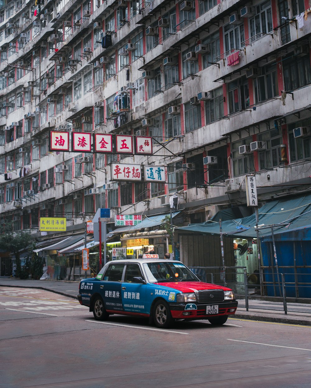 blue car on road near building during daytime