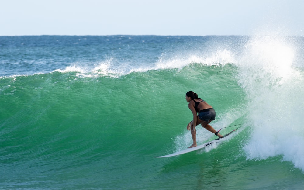 man in black shorts surfing on sea waves during daytime