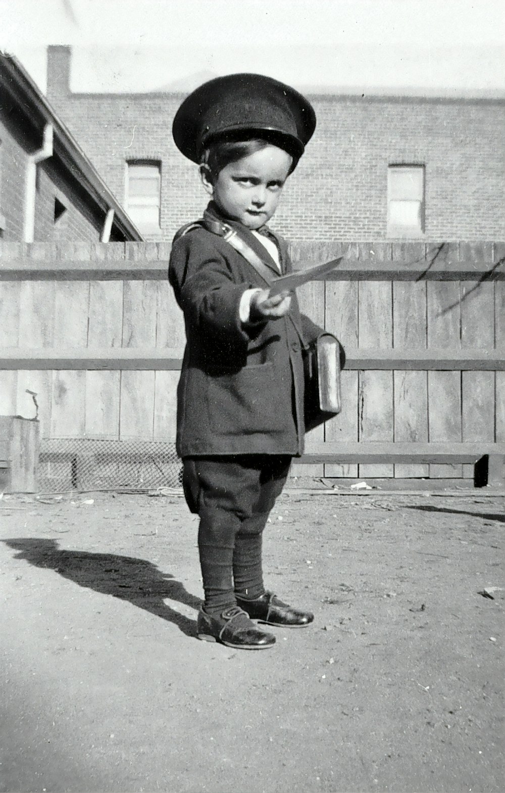 menino na camisa preta de manga comprida segurando um bastão