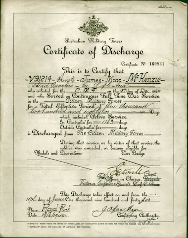 A formal document titled 'Certificate of Discharge' from the Australian Military Forces. It contains printed and handwritten text certifying the discharge of a private, along with dates, service details, and signatures. The background is a light, aged paper, with a green border and an emblem at the top center.
