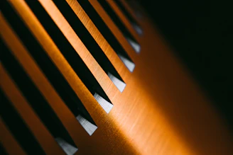 Close-up of a matte black surface with fine golden lines creating an abstract architectural pattern.