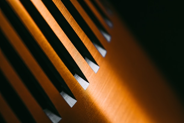 A close-up of a luxurious seamless wallpaper with a subtle gold geometric pattern on a deep black background.