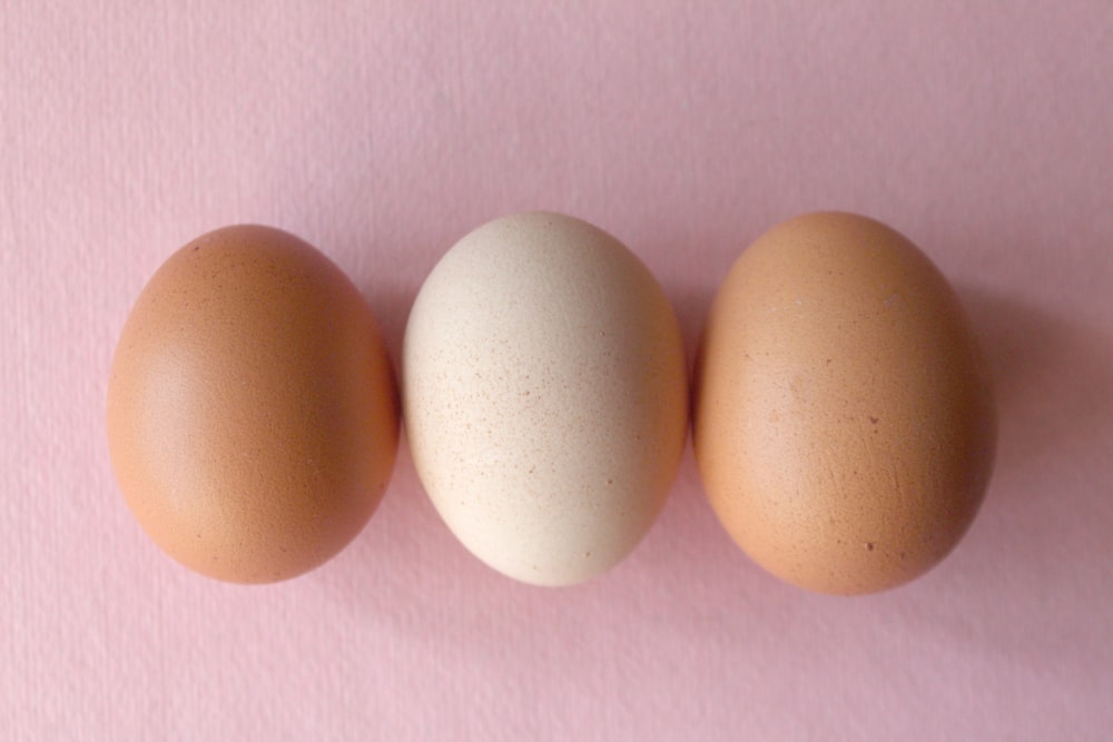 2 brown eggs on pink textile