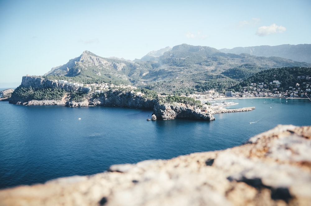 body of water near mountain during daytime