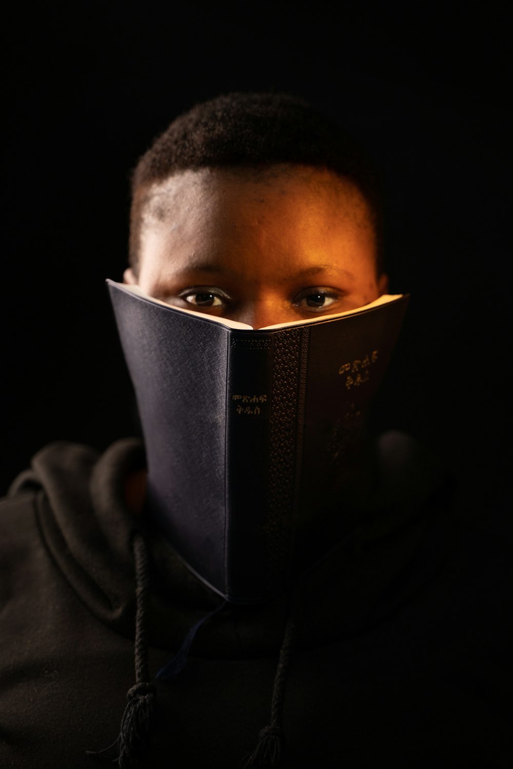 man in black hoodie reading book