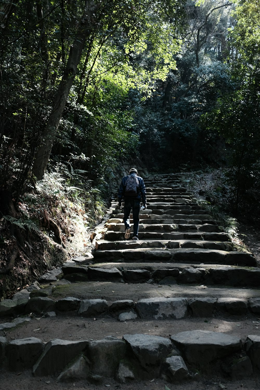 man in black jacket walking on gray concrete stairs