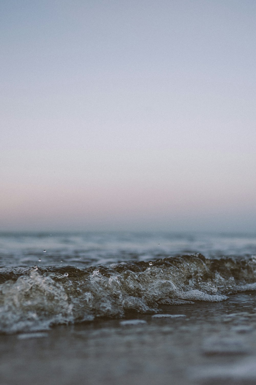 ocean waves crashing on shore during daytime