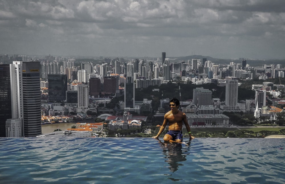 femme en haut de bikini noir assis sur la piscine pendant la journée