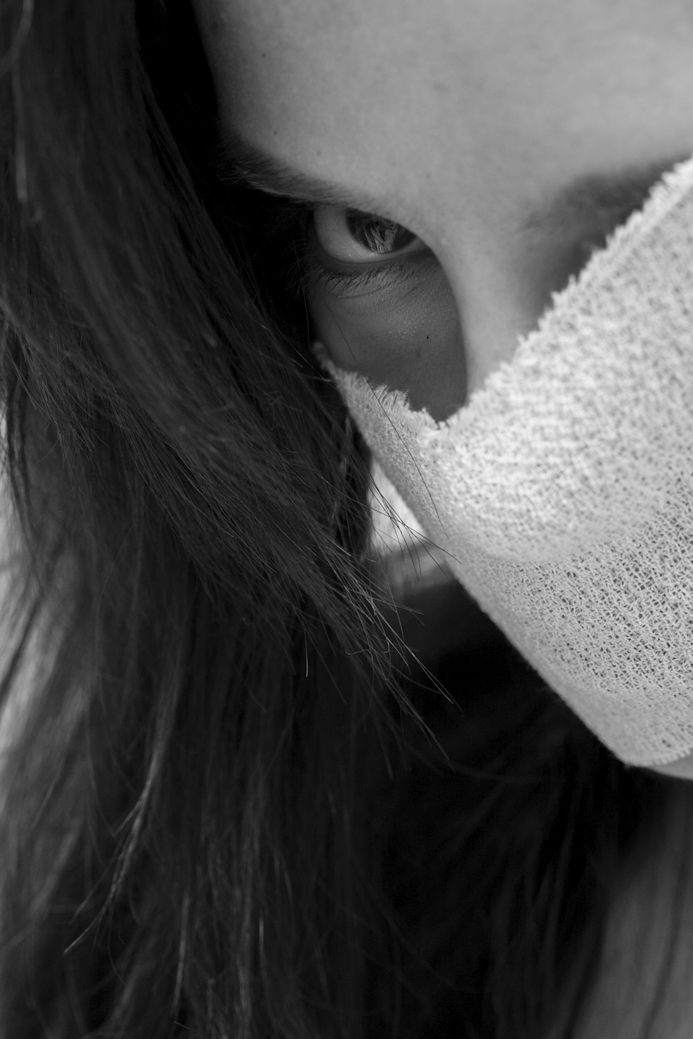 grayscale photo of woman covering her face with white towel