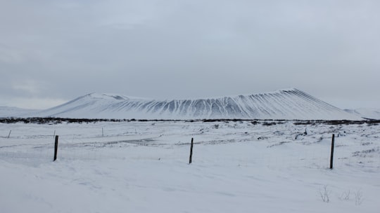 snow covered field under white cloudy sky during daytime in Hverfjall Iceland