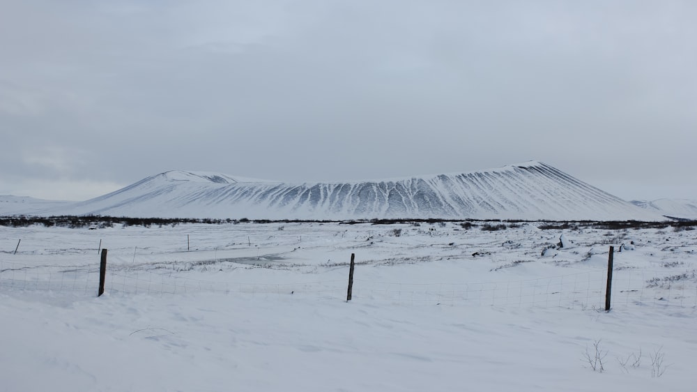 snow covered field under white cloudy sky during daytime