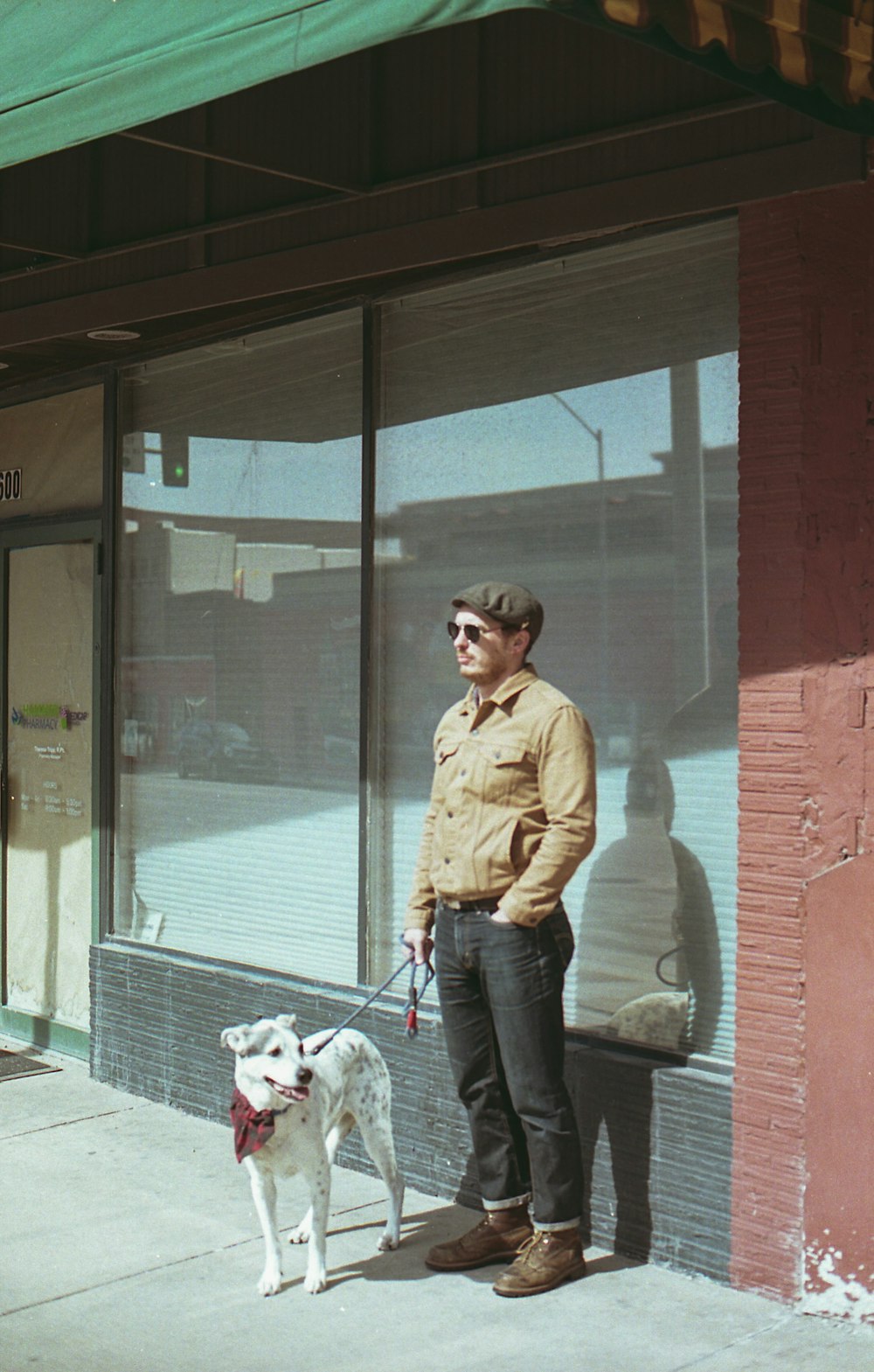 man in brown jacket standing beside glass door