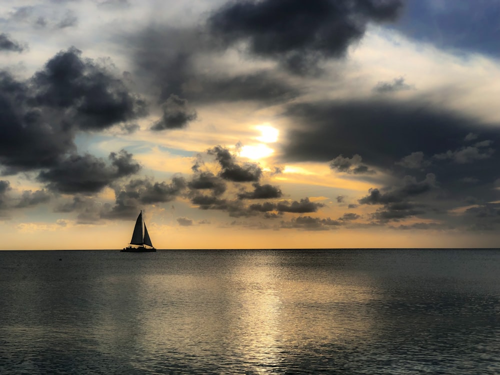 Segelboot auf See unter bewölktem Himmel tagsüber