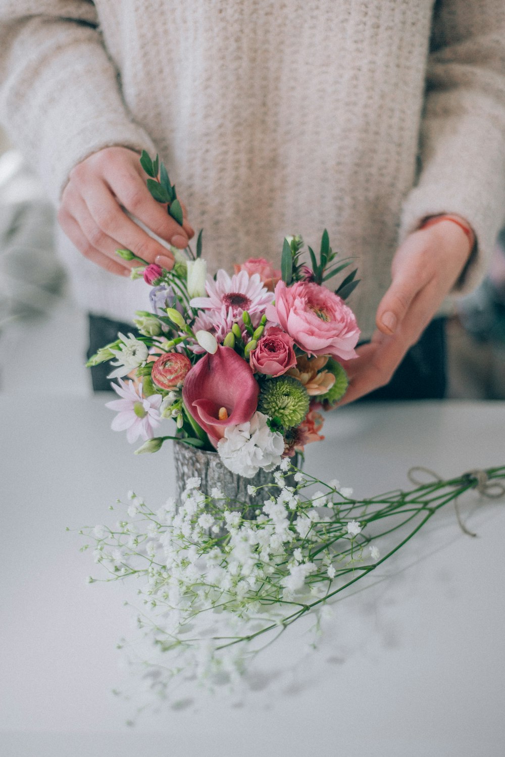 Person mit rosa und weißen Blüten