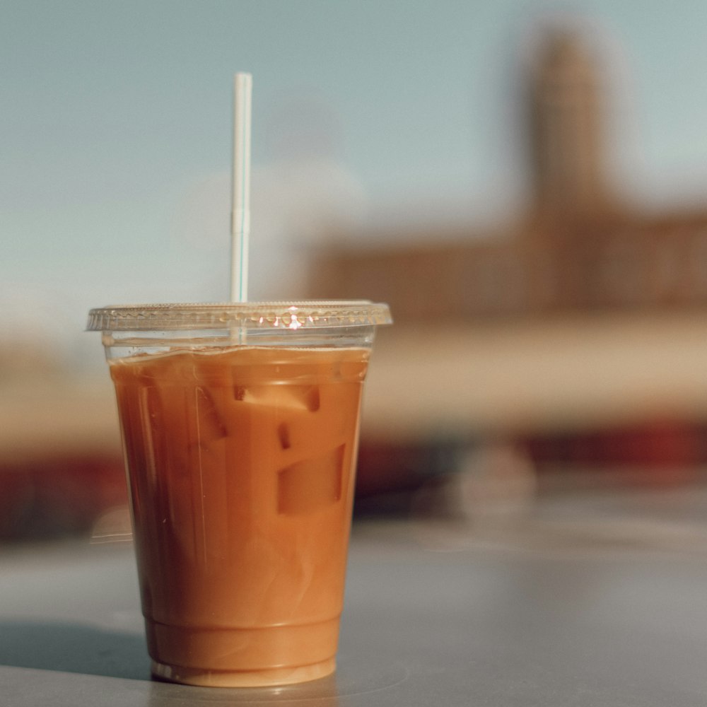 orange and white plastic cup with white straw