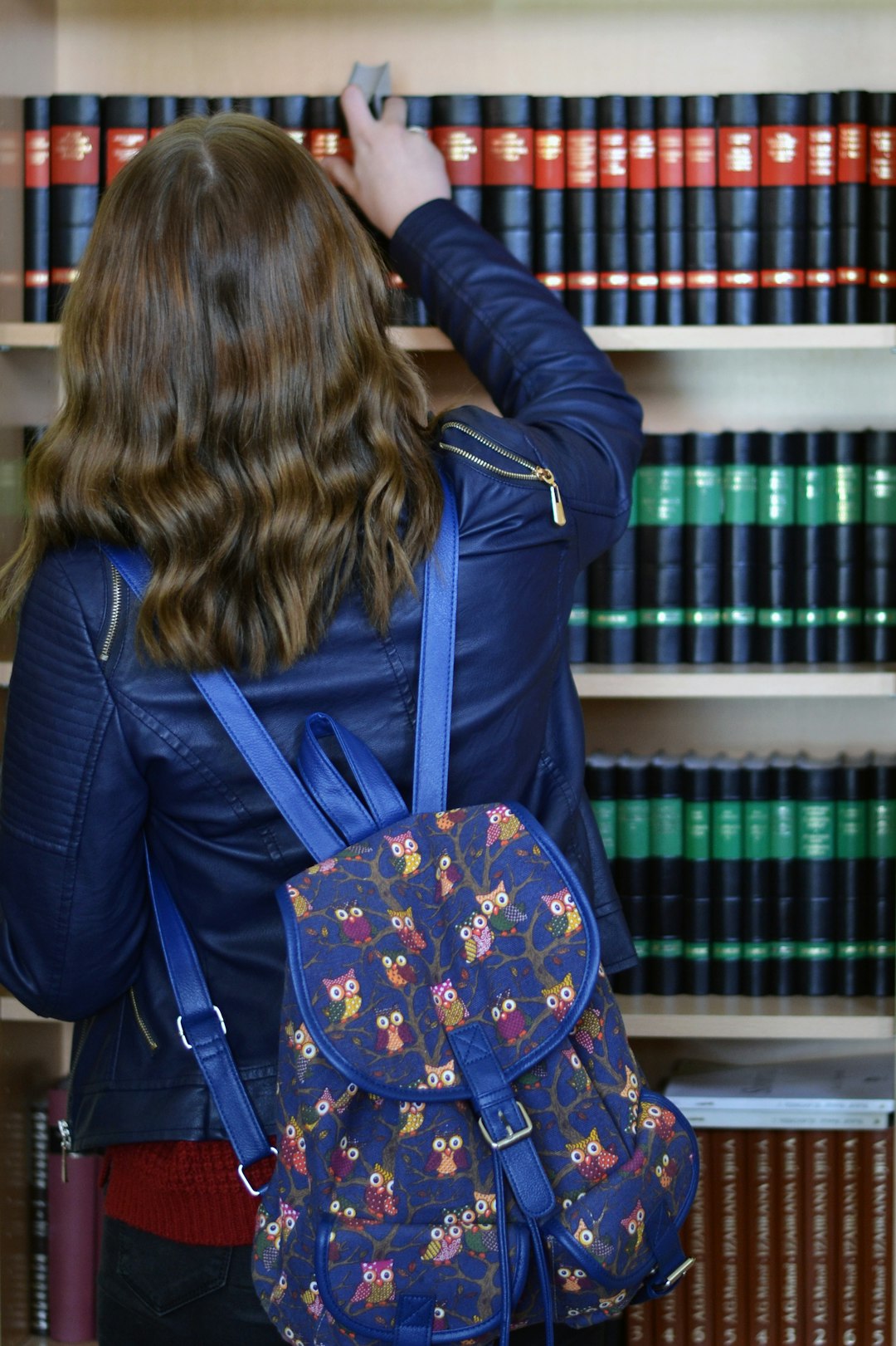 woman in blue jacket with blue and brown backpack
