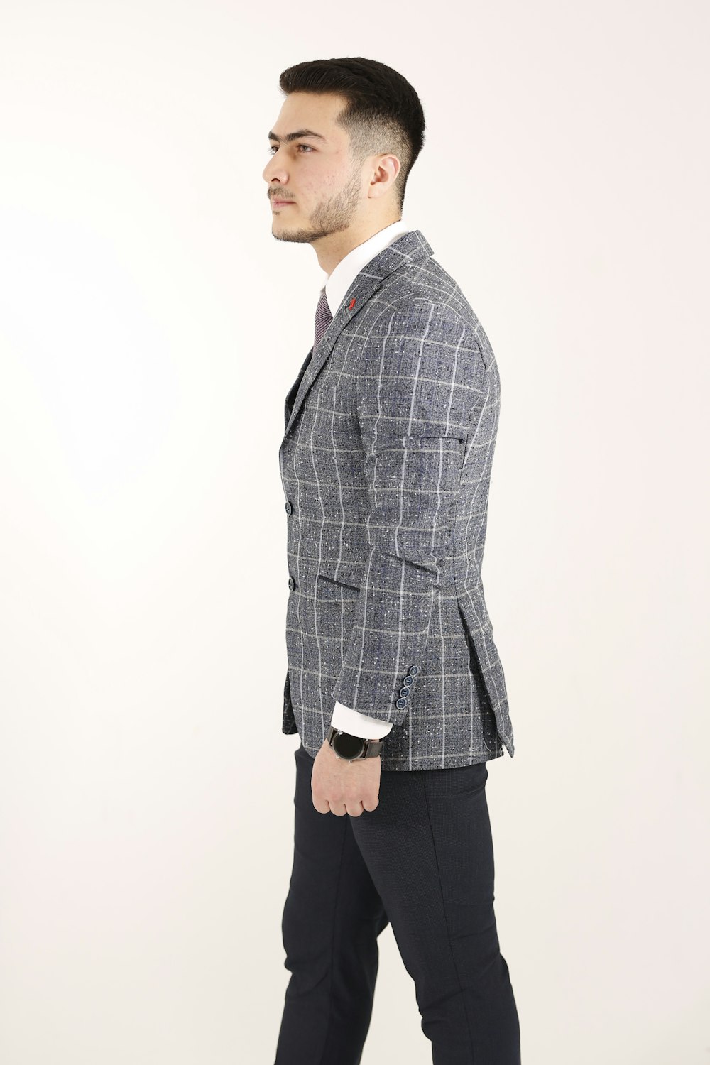 man in gray and black plaid blazer standing