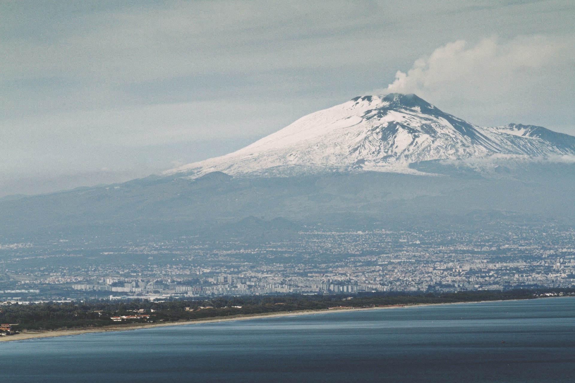 snow covered mountain near body of water during daytime