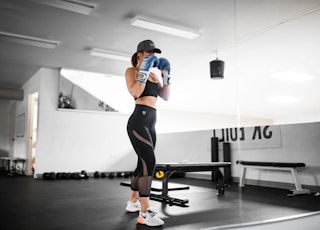 woman in orange and black shirt and black leggings doing exercise