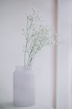 Close-up of fresh flowers in a minimalist vase on a bedside table creating a welcoming touch.