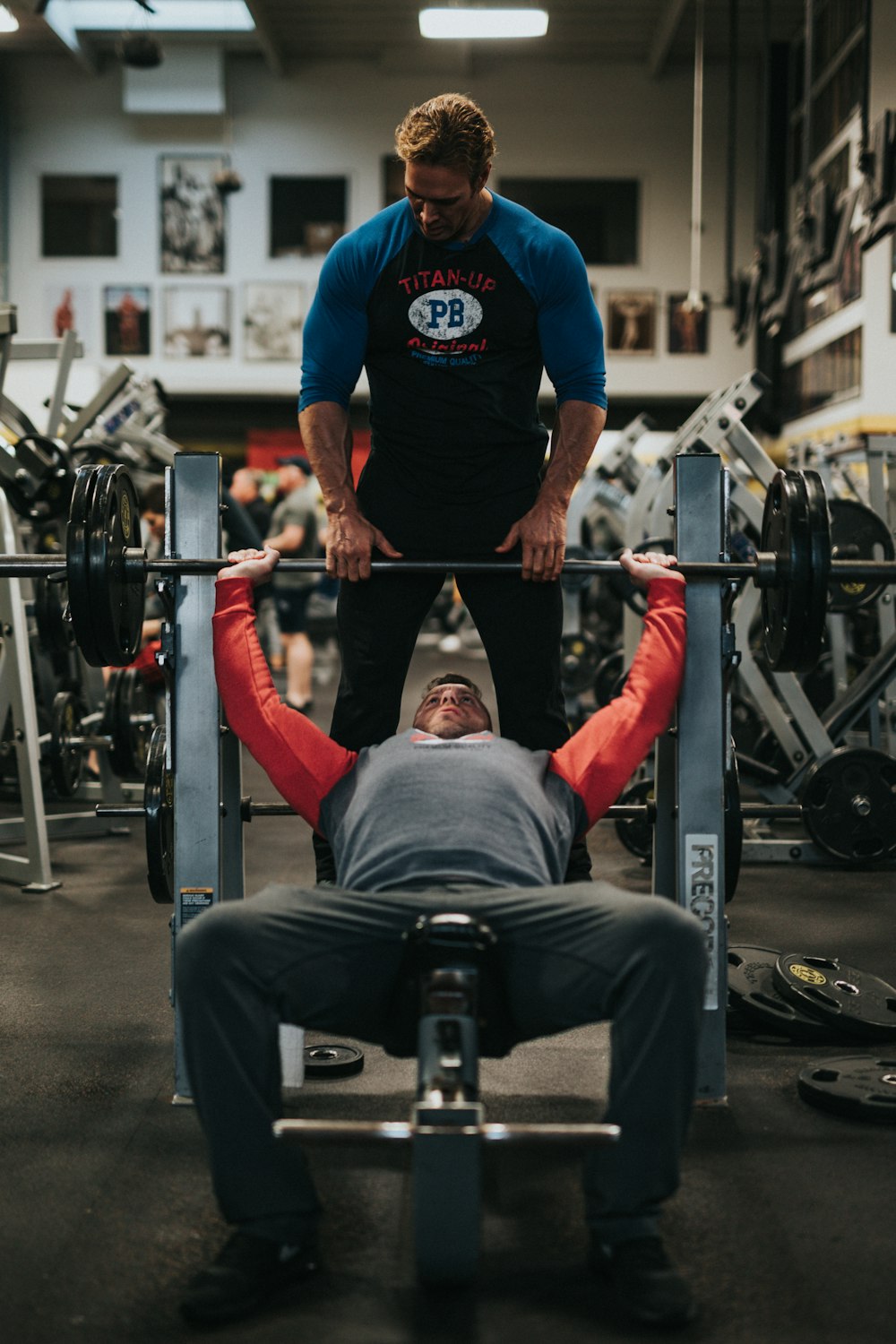 man in black crew neck t-shirt and gray pants sitting on black and red bench