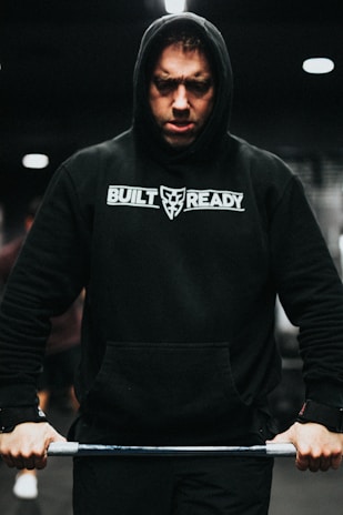 Close-up of a red and black Crossfit WCG hoodie stretched during an intense workout.