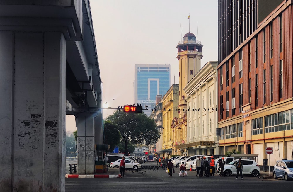 pessoas andando na rua perto de edifício de concreto bege durante o dia