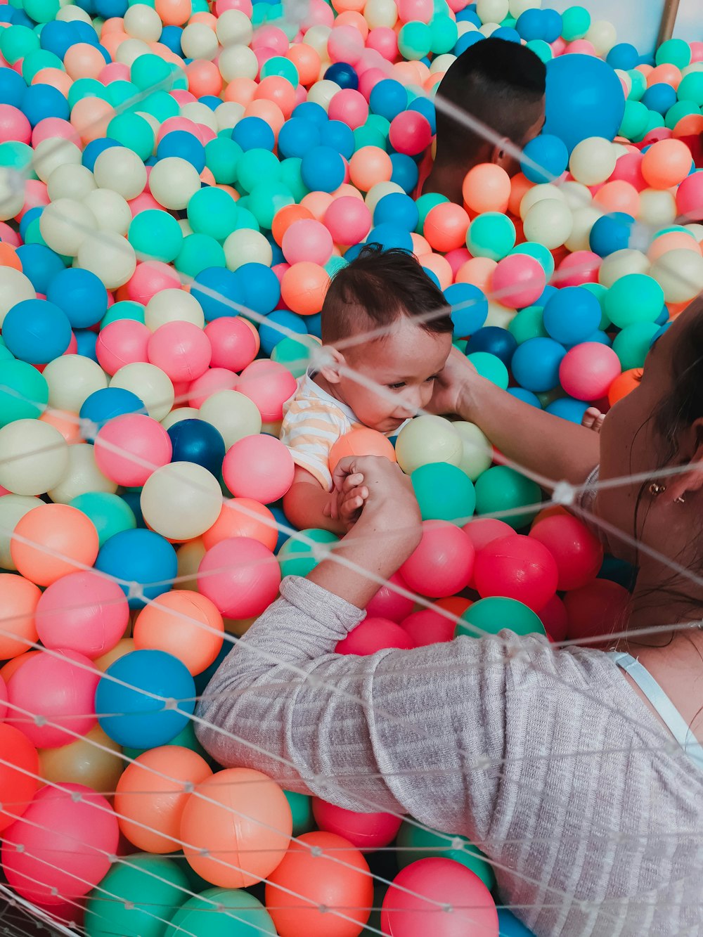 woman in gray shirt and blue denim jeans sitting on balloons