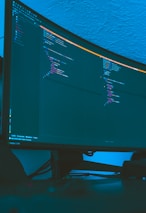 Developers reviewing code together on a large monitor with Android logos visible.