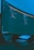 A large curved monitor displays a dark-themed code editor, featuring lines of code written in a structured format. The background is a textured ceiling with soft blue lighting creating a calm ambiance.