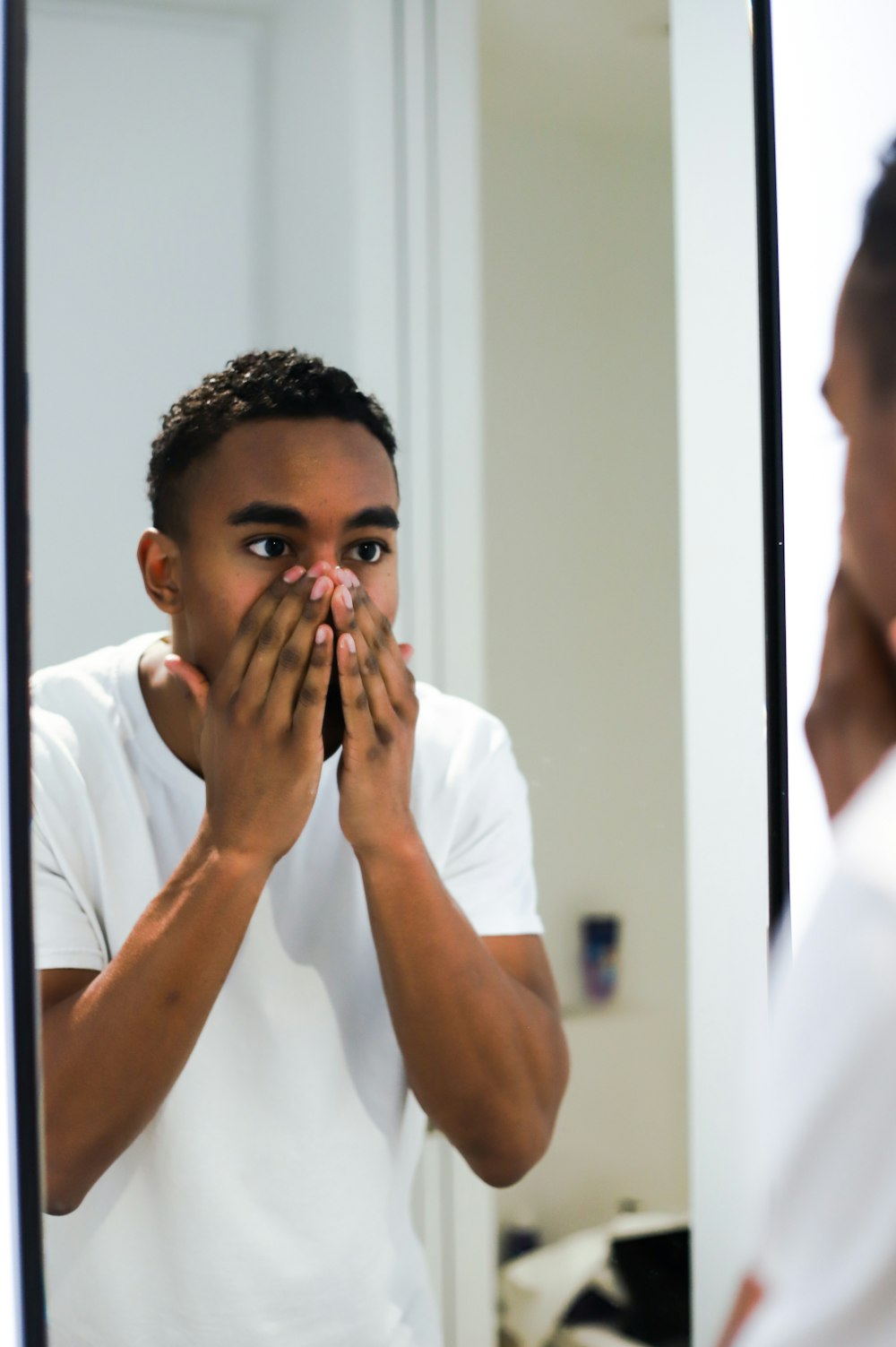 man in white button up shirt covering his mouth