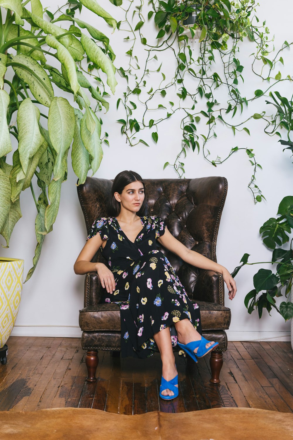 woman in black and white floral dress sitting on brown couch