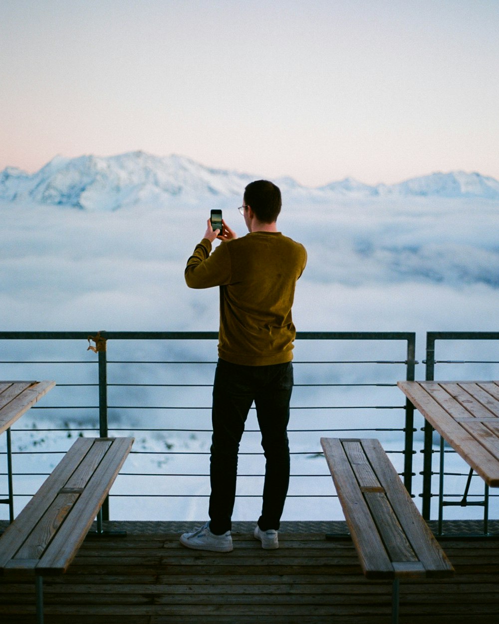 man in yellow shirt and black pants standing on wooden dock during daytime