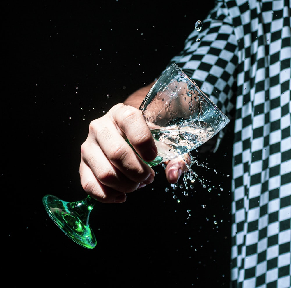 person holding clear glass cup with green liquid