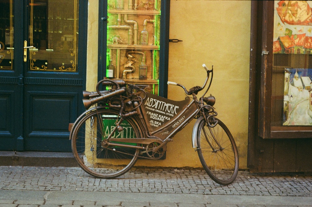 Vélo de ville marron garé à côté d’un mur peint en vert et jaune